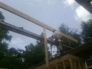 Carpenter setting a ridge beam over a new addition frame — Ice Dam Removal by Roofing Brothers in Portsmouth