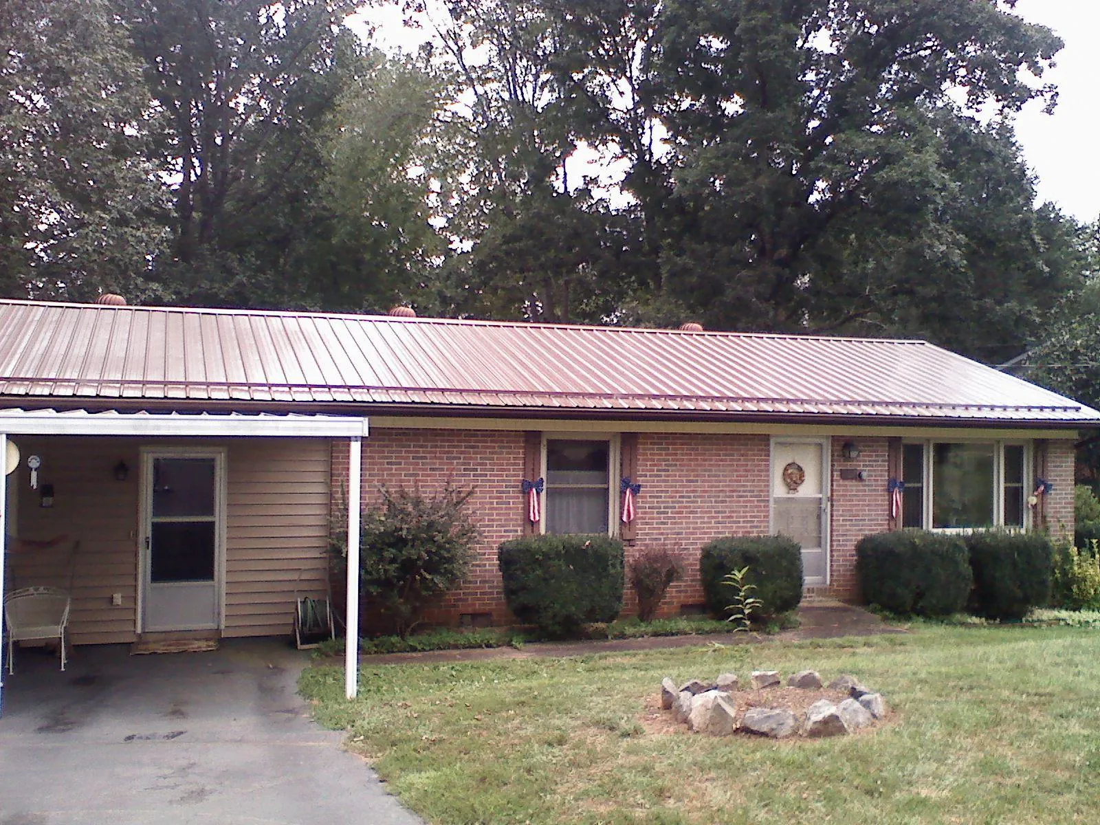 Bronze metal roof and carport on a brick ranch home — Roof Repair work by our crew in Portsmouth